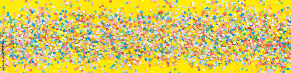 Frame made of colored confetti. Yellow background