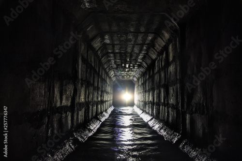 Dirty urban sewage flowing through rectangular sewer tunnel under Moscow
