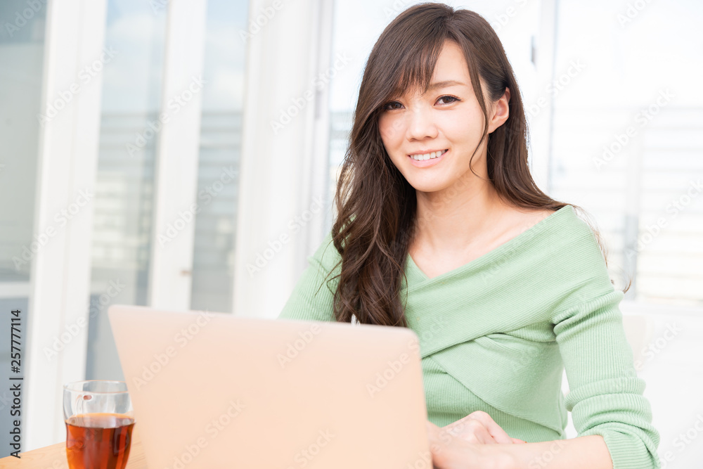 部屋でラップトップコンピューターを見る女性 部屋でラップトップコンピューターを見る女性