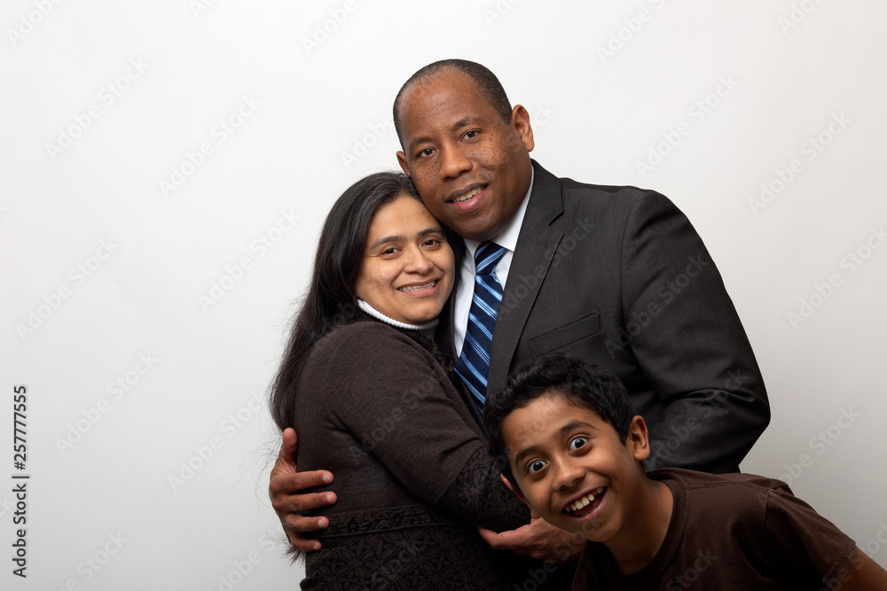Mixed Race Couple being Photo Bombed by Son on Light Gray Background Mixed Race Couple being Photo Bombed by Son on Light Gray Background