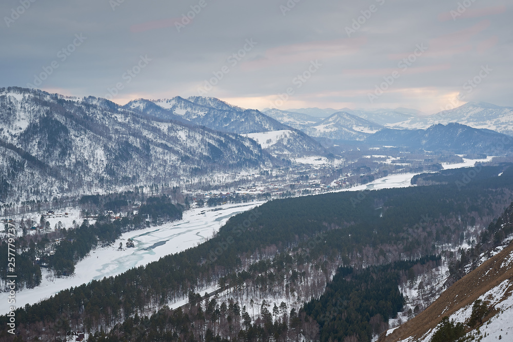 Storm clouds in the mountains. mountain gorge by a frozen river with forest gray stormy winter day Storm clouds in the mountains. mountain gorge by a frozen river with forest gray stormy winter day
