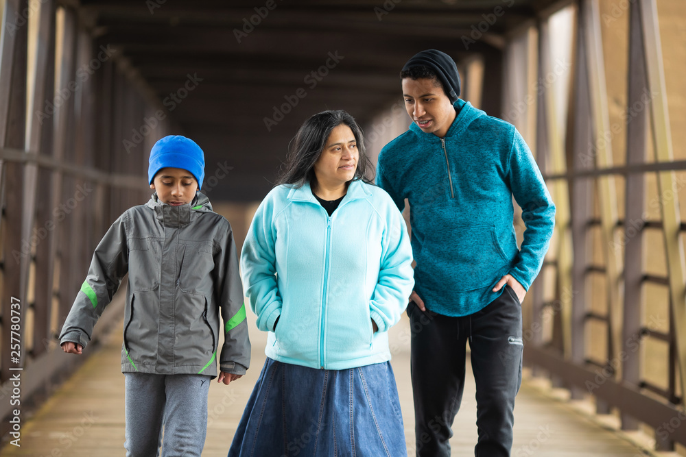 Hispanic Mother Walks With Sons On A Bridge Hispanic Mother Walks With Sons On A Bridge