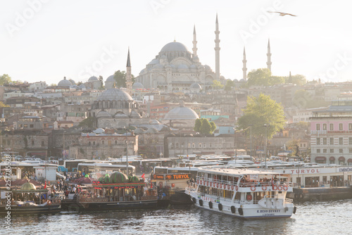 Istanbul, Turkey - 04 22 2016: Floating restaurants and the New Mosque Yeni Cami in Eminonu. View from Galata Bridge, Golden Horn, Istanbul, Turkey