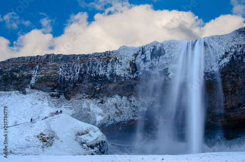 Iceland waterfall seljalandsfoss frozen in winter with cloudy sky