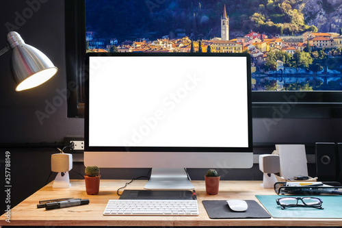 Graphic designer's workspace with a pen tablet, a computer and white backgroud for text with beautiful view of Lakecomo,Italy from Window photo