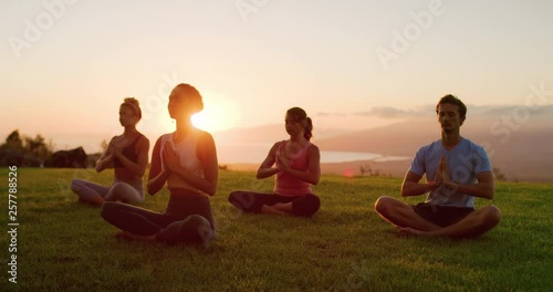 Zen meditation practice at sunset, group of diverse young people meditating together at sunset, zen health and wellness
