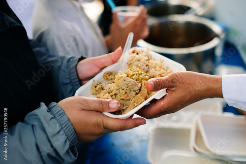 Volunteers serving charity food to the poor: the concept of hunger