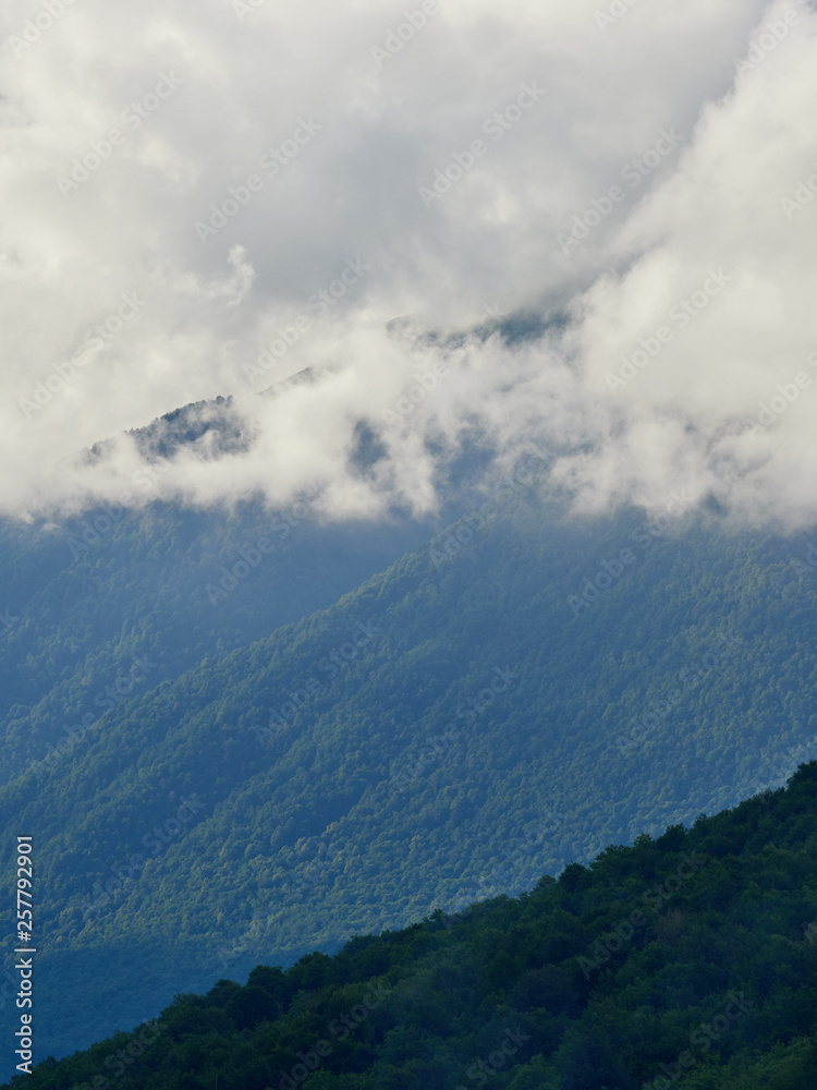 High green mountains with peaks in thick clouds