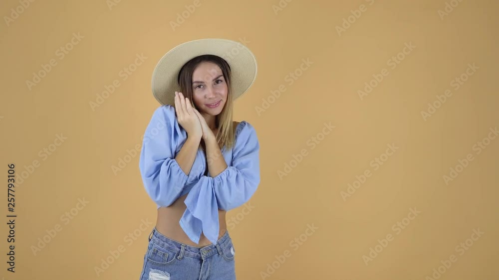 wonderful model in blue blouse and straw hat posing with hands pressed to cheek wonderful model in blue blouse and straw hat posing with hands pressed to cheek