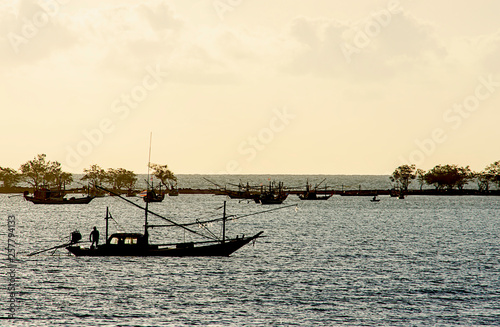 Fisherman on the boat and fishing boats parked on the sea coastline at Laem thian beach   Chumphon in Thailand.