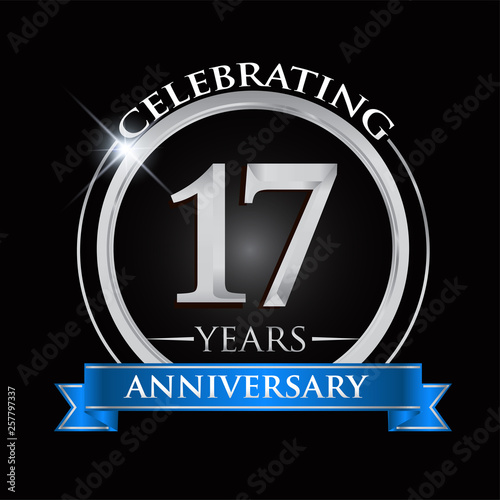 Celebrating 17 years anniversary logo. with silver ring and blue ribbon.