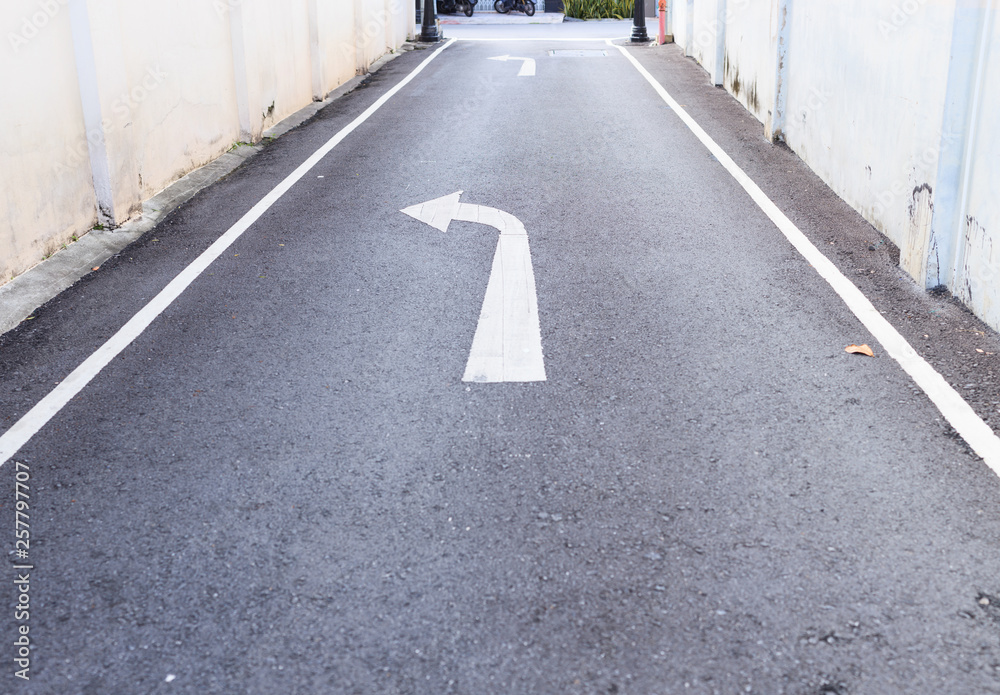 custom made wallpaper toronto digitalwhite arrow traffic sign indicates minor road to turn left to major road and white footpath lines on the asphalt rural road in small alley. Transportation, road safety, compliance and warning concept