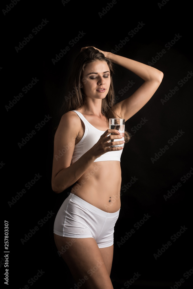 Obraz premium Female fitness model holding a water glass