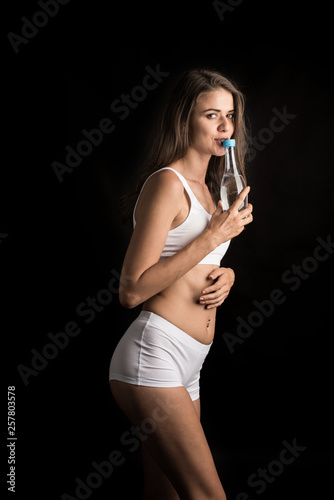 Female fitness model holding a water bottle