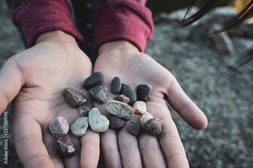 Child’s young hands holding colorful pebbles