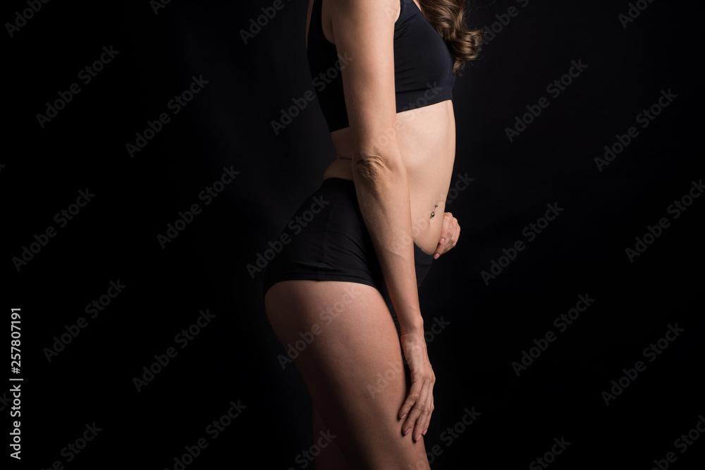 Fototapeta premium Beautiful woman with healthy body on black background