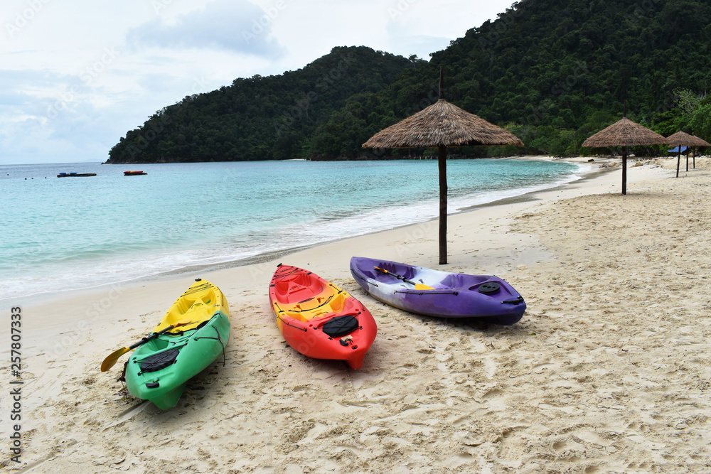 Colourful of kayaks stand on a sandy beach in Vacation. Background