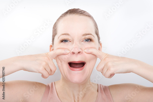 facial gymnastics. the girl does massage and rejuvenating exercises for the face