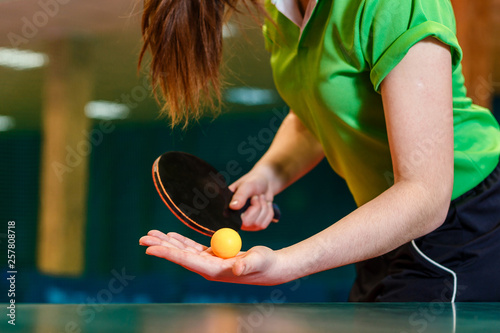black ping pong paddle and ball in female hands close. Serve the ball in table tennis