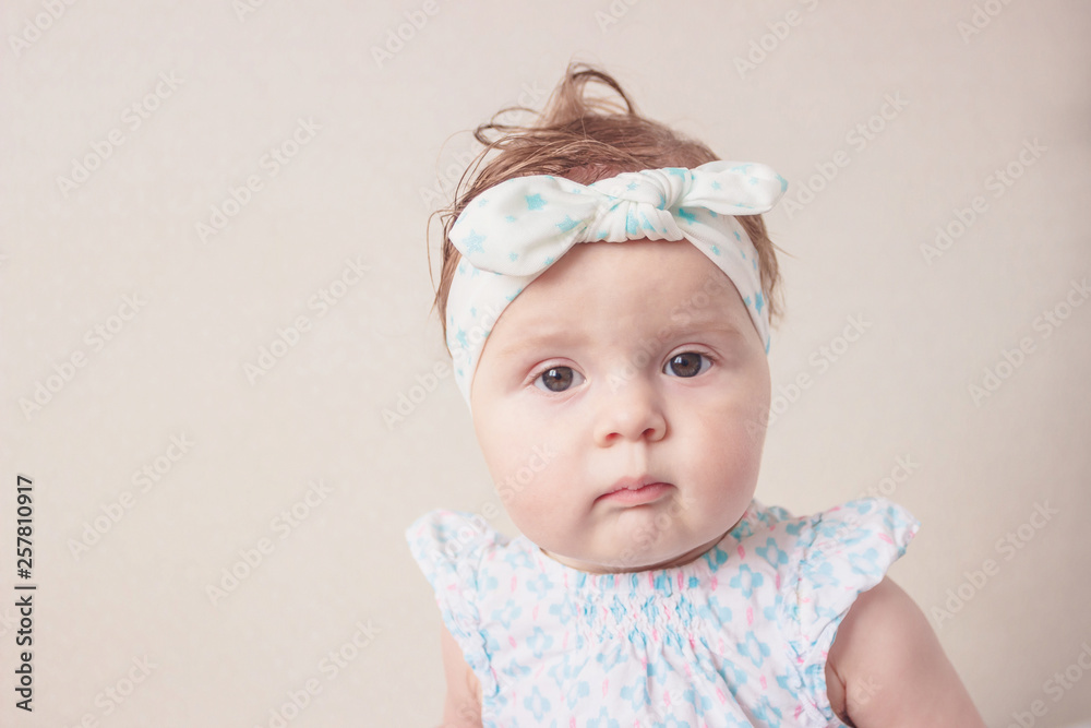Portrait of eight month girl in the dress with headband, indoors, blurred background Portrait of eight month girl in the dress with headband, indoors, blurred background