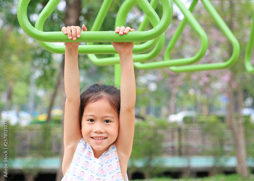 Close up little girl playing on gymnastic ring on playground outdoor. Close up little girl playing on gymnastic ring on playground outdoor.