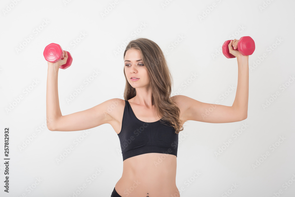 Portrait of young beautiful woman making physical exercises with dumbbells Portrait of young beautiful woman making physical exercises with dumbbells