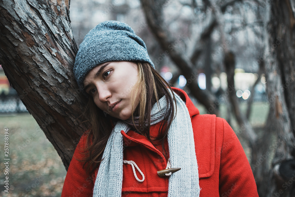 Moody portrait of young adult female in the branches of trees during blue hour, selective focus Moody portrait of young adult female in the branches of trees during blue hour, selective focus