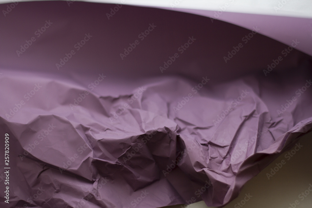 background of crumpled purple paper on a blurred white background