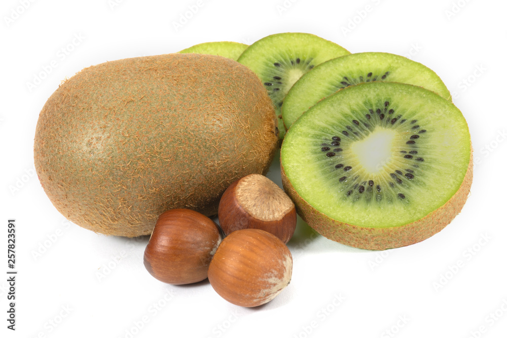 Whole and sliced kiwi fruit next to hazelnuts Whole and sliced kiwi fruit next to hazelnuts