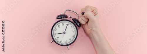 Female hand with alarm clock. Morning concept