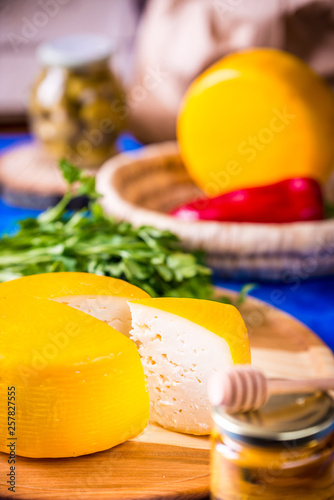 Cheese wheel on a wooden board. Blurred background. photo