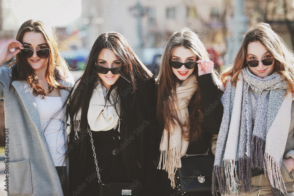 four beautiful women are walking around the city and having fun