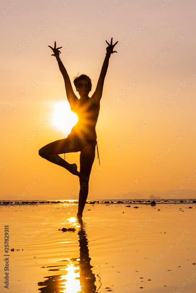 Woman on the beach at sunset