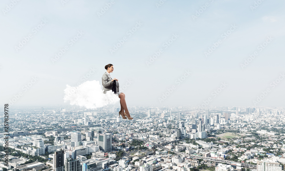 Businesswoman or accountant on cloud floating high above modern city Businesswoman or accountant on cloud floating high above modern city