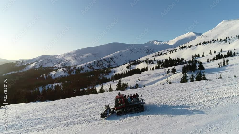 People are riding in the snowmobile on the hills of a mountain, stunning background of the morning sun and low clouds on the horizon, 4k People are riding in the snowmobile on the hills of a mountain, stunning background of the morning sun and low clouds on the horizon, 4k