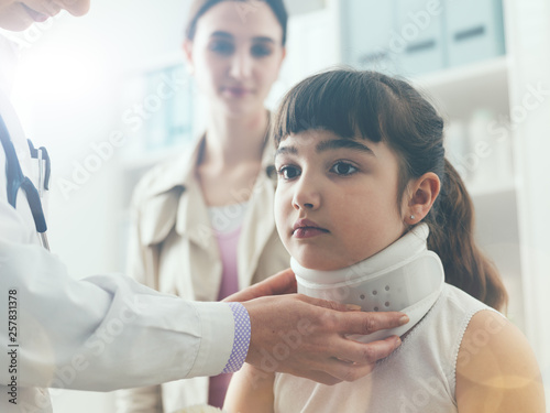Doctor visiting a young girl with cervical collar