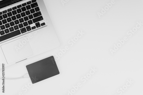 Laptop keyboard, storage drive or hard disk on yellow background with selective focus, crop fragment, business, backup, copy space concept. Black and White