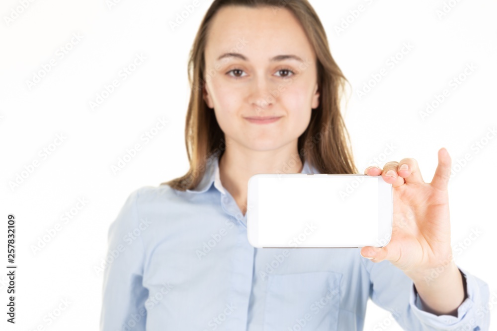 Cheerful cute woman showing smartphone screen isolated on a white background Cheerful cute woman showing smartphone screen isolated on a white background