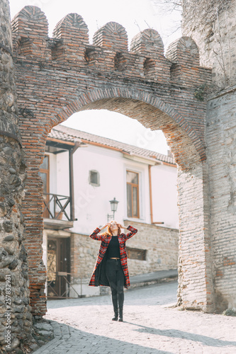 Girl travel blogger walking the streets. The buildings of the town Signagi, Georgia.