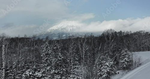 Aerial view of a large mountain in a snow covered landscape