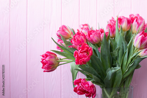 Fototapeta Naklejka Na Ścianę i Meble -  Colorful bouquet of tulips on pink wooden background. Top view