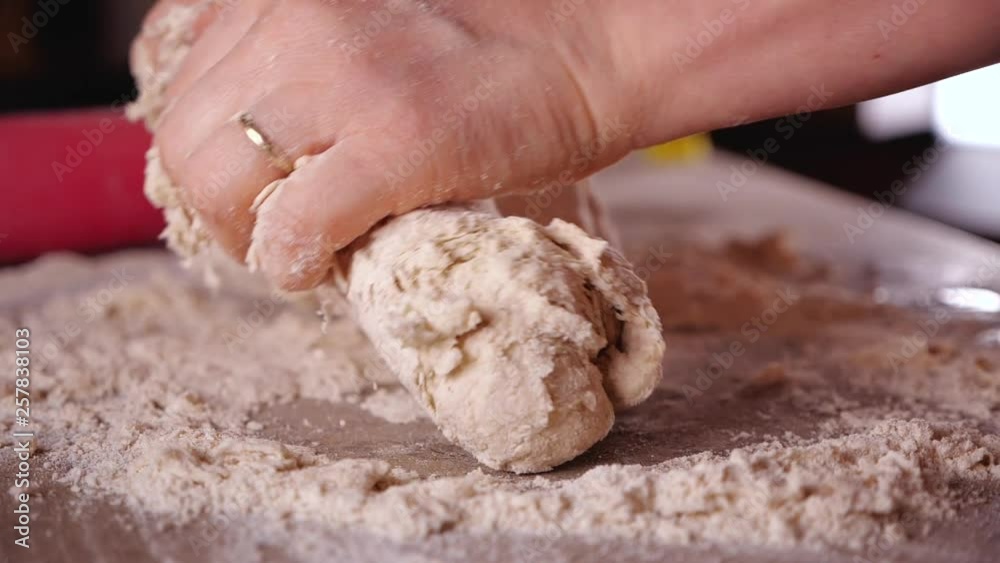 Making bread or pizza - woman hands mixing ingredients and kneading the dough, closeup, slow motion Making bread or pizza - woman hands mixing ingredients and kneading the dough, closeup, slow motion