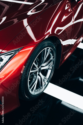 new shiny red automobile with metallic wheel in car showroom © LIGHTFIELD STUDIOS