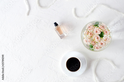 Female light fletley with cosmetics, beads, coffee and roses.