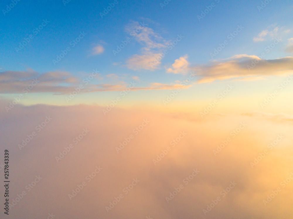 Fototapeta premium Widok z lotu ptaka Białe chmury na niebieskim niebie. Widok z góry. Widok z drona. Widok z lotu ptaka z lotu ptaka. Widok z góry z lotu ptaka Cloudscape. Tekstura chmur. Widok z góry. Wschód lub zachód słońca nad chmurami