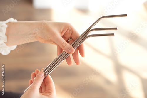 Girl is holding stainless steel straws to reduce the amount of plastic waste in the environment photo