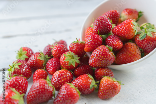 Strawberries heap on white table.