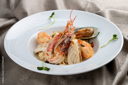 Tagliatelle with seafood on textile background