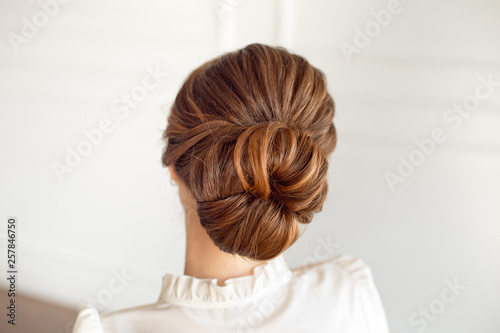 Rear view of female hairstyle medium bun with dark hair.
