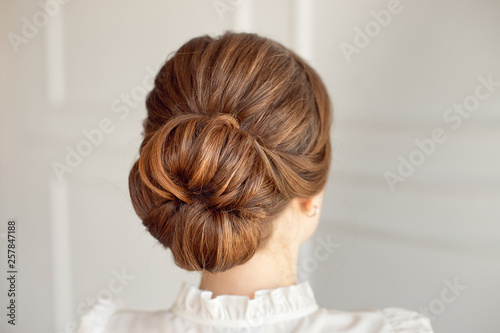 Rear view of female hairstyle medium bun with dark hair.